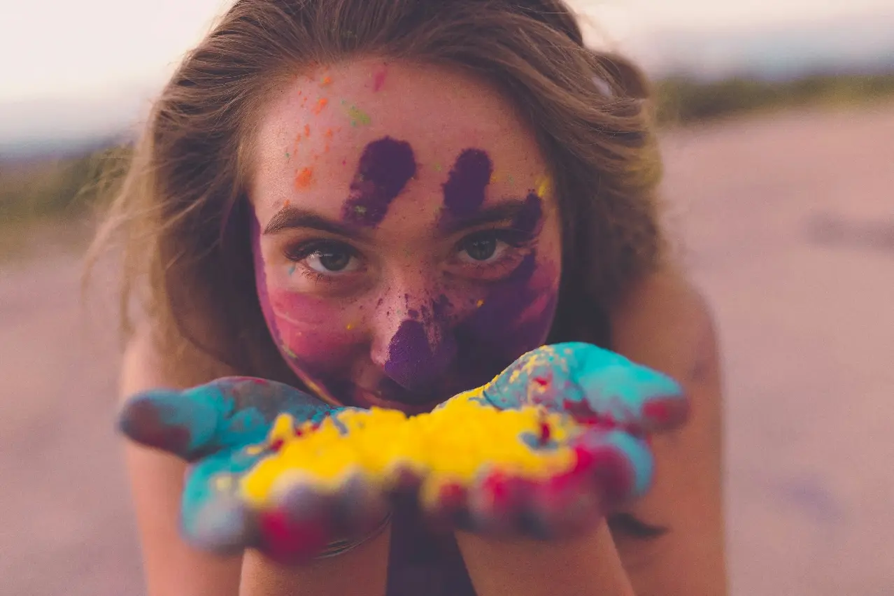 Jeune femme soufflant sur des pigments de peinture