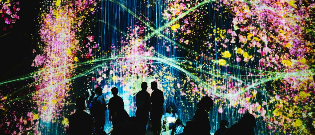 Installation immersive lumineuse avec visiteurs dans une exposition numérique.