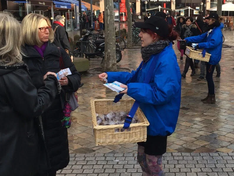 Animation de street marketing avec distribution de prospectus et échantillons en centre-ville.