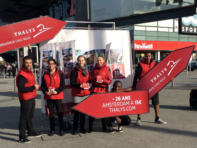 Équipe d’animateurs distribuant des flyers pour une campagne promotionnelle Thalys en centre-ville.