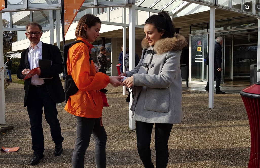 Sampling campus Burger King : une ambassadrice remet un échantillon à une étudiante devant l'entrée du site